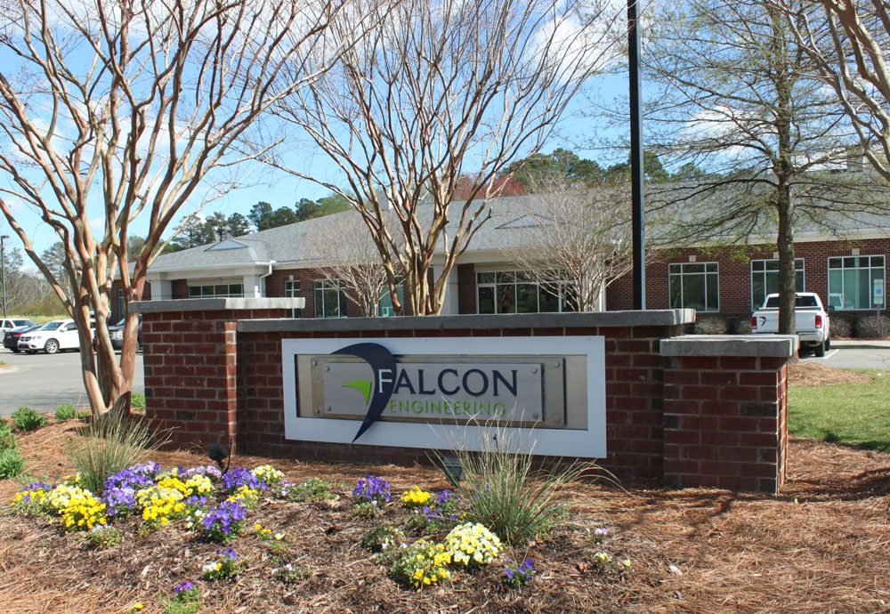 Sign surrounded by flowers at exterior of Falcon headquarters